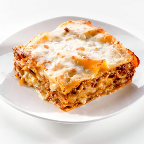 lasagna piece plate with minced meat and melted cheese close-up on white background